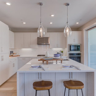 Open concept kitchen pictures - Inspiration for a l-shaped open concept kitchen remodel in San Francisco with flat-panel cabinets, white cabinets, an island and white countertops