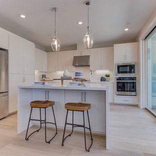 Open concept kitchen pictures - Open concept kitchen - l-shaped open concept kitchen idea in San Francisco with flat-panel cabinets, white cabinets, an island and white countertops