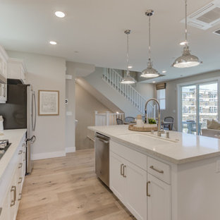 Open concept kitchen pictures - L-shaped open concept kitchen photo in San Francisco with an undermount sink, recessed-panel cabinets, white cabinets, an island and stainless steel appliances