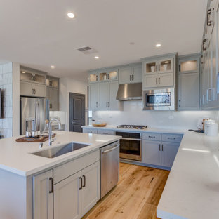 Open concept kitchen remodeling - Inspiration for a l-shaped open concept kitchen remodel in San Francisco with an undermount sink, recessed-panel cabinets, gray cabinets, stainless steel appliances and an island
