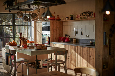 This is an example of a medium sized rustic kitchen in Other with a double-bowl sink, light wood cabinets, concrete worktops, grey splashback, cement tile splashback, stainless steel appliances, an island and grey worktops.