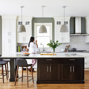 Transitional kitchen pictures - Kitchen - transitional single-wall medium tone wood floor and brown floor kitchen idea in DC Metro with an undermount sink, shaker cabinets, white cabinets, white backsplash, subway tile backsplash, stainless steel appliances, an island and white countertops