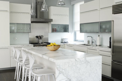 Inspiration for a contemporary l-shaped kitchen remodel in New York with stainless steel appliances, white cabinets, marble countertops and flat-panel cabinets