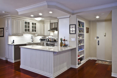 Inspiration for a small contemporary l-shaped dark wood floor open concept kitchen remodel in New York with a single-bowl sink, raised-panel cabinets, white cabinets, white backsplash, stainless steel appliances and a peninsula