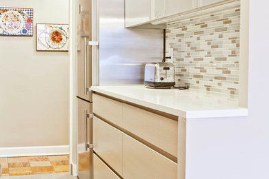 Example of a small trendy galley gray floor enclosed kitchen design in New York with an undermount sink, flat-panel cabinets, gray cabinets, quartz countertops, multicolored backsplash, glass tile backsplash, stainless steel appliances and no island