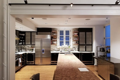 Example of a large minimalist light wood floor and brown floor kitchen design in New York with recessed-panel cabinets, stainless steel cabinets, multicolored backsplash, marble backsplash, stainless steel appliances, an island and multicolored countertops