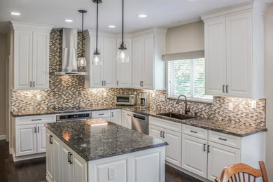 Inspiration for a mid-sized transitional l-shaped dark wood floor and multicolored floor eat-in kitchen remodel in St Louis with an undermount sink, raised-panel cabinets, white cabinets, quartz countertops, multicolored backsplash, glass sheet backsplash, stainless steel appliances, an island and black countertops