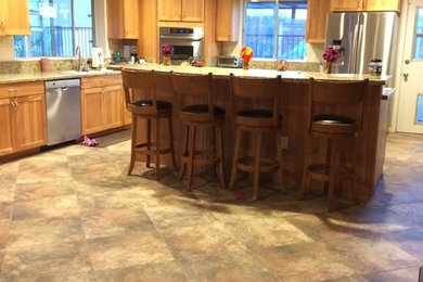 Stilmix Küche in L-Form mit Vorratsschrank, hellen Holzschränken, Küchengeräten aus Edelstahl, Porzellan-Bodenfliesen und Kücheninsel in Phoenix