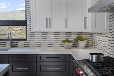 Example of a large trendy l-shaped vinyl floor enclosed kitchen design in Phoenix with an undermount sink, shaker cabinets, dark wood cabinets, granite countertops, multicolored backsplash, mosaic tile backsplash, stainless steel appliances and an island