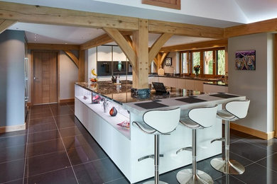This is an example of a medium sized contemporary l-shaped kitchen in Other with a breakfast bar and black floors.