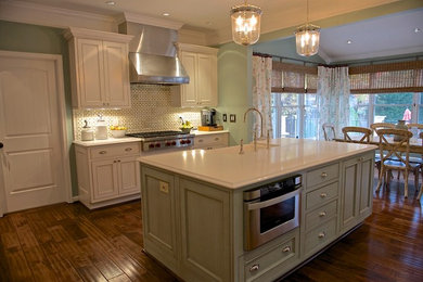 Eat-in kitchen - transitional l-shaped medium tone wood floor eat-in kitchen idea in DC Metro with a farmhouse sink, raised-panel cabinets, white cabinets and an island