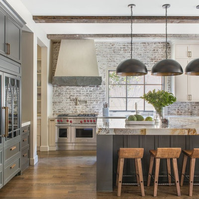Kitchen - country l-shaped medium tone wood floor and brown floor kitchen idea in Dallas with gray cabinets, brick backsplash, stainless steel appliances, an island, beige countertops and recessed-panel cabinets