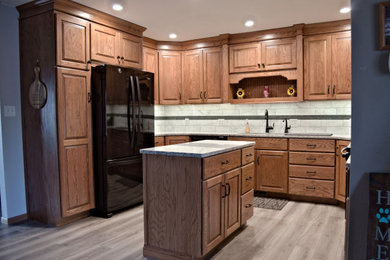Kitchen - traditional u-shaped kitchen idea in Other with raised-panel cabinets, medium tone wood cabinets, black appliances and an island