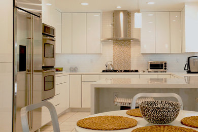 ロサンゼルスにあるモダンスタイルのおしゃれなキッチン (フラットパネル扉のキャビネット、白いキャビネット、クオーツストーンカウンター、白いキッチンパネル、サブウェイタイルのキッチンパネル、シルバーの調理設備) の写真
