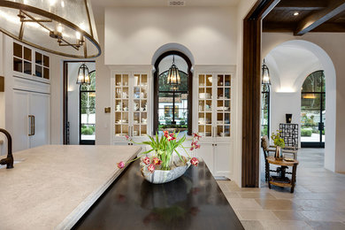 Large tuscan l-shaped limestone floor and gray floor open concept kitchen photo in Other with a farmhouse sink, raised-panel cabinets, white cabinets, limestone countertops, multicolored backsplash, ceramic backsplash, an island and gray countertops