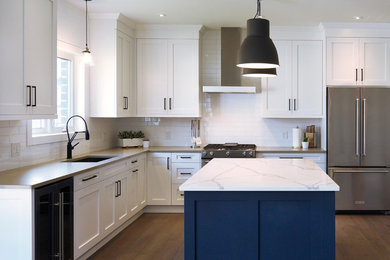 Eat-in kitchen - large transitional l-shaped medium tone wood floor eat-in kitchen idea in Toronto with recessed-panel cabinets, white cabinets, an island, a double-bowl sink, quartzite countertops, white backsplash, subway tile backsplash and stainless steel appliances