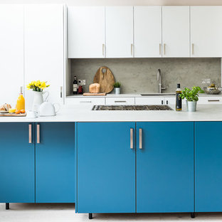 Design ideas for a large contemporary kitchen in London with an integrated sink, flat-panel cabinets, turquoise cabinets, concrete benchtops, grey splashback, slate splashback, stainless steel appliances, light hardwood floors, with island and grey floor.