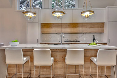 This is an example of a large scandinavian single-wall kitchen/diner in Toronto with a built-in sink, flat-panel cabinets, light wood cabinets, marble worktops, white splashback, marble splashback, stainless steel appliances, light hardwood flooring, an island, beige floors and white worktops.