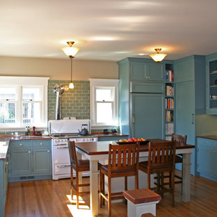 Immagine di una cucina chic di medie dimensioni con lavello a vasca singola, ante di vetro, ante blu, elettrodomestici bianchi, pavimento in legno massello medio, paraspruzzi blu, paraspruzzi con piastrelle diamantate e top in rame