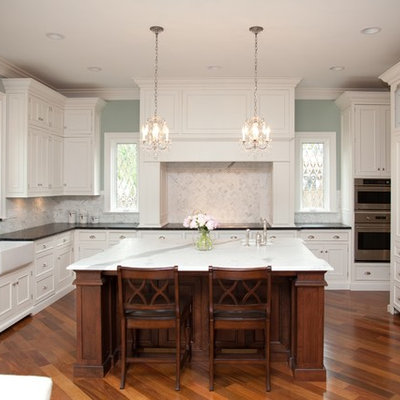 Elegant kitchen photo in Chicago with recessed-panel cabinets, a farmhouse sink, white backsplash and stone tile backsplash