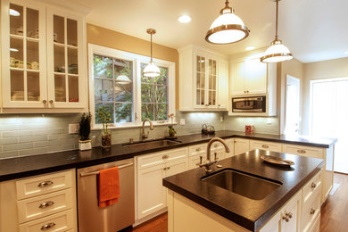 Large transitional l-shaped dark wood floor and brown floor eat-in kitchen photo in San Francisco with an undermount sink, shaker cabinets, white cabinets, granite countertops, green backsplash, ceramic backsplash, stainless steel appliances and an island