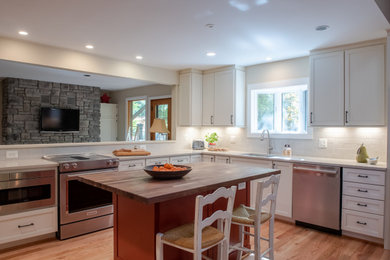 Large eclectic light wood floor eat-in kitchen photo in DC Metro with an undermount sink, shaker cabinets, white cabinets, quartz countertops, beige backsplash, ceramic backsplash, stainless steel appliances, an island and beige countertops