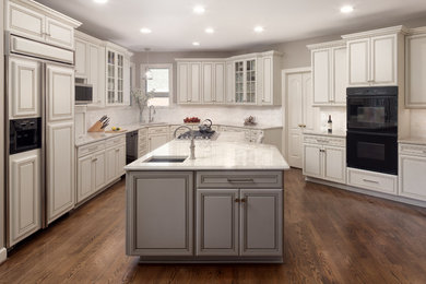 Example of a large classic u-shaped dark wood floor and brown floor eat-in kitchen design in DC Metro with an undermount sink, raised-panel cabinets, white cabinets, quartzite countertops, white backsplash, marble backsplash, black appliances, an island and white countertops