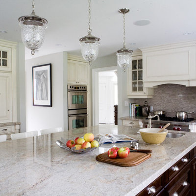Example of a classic kitchen design in Toronto with glass-front cabinets, stainless steel appliances, white cabinets and granite countertops