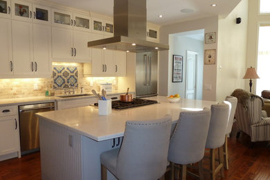 Large elegant l-shaped medium tone wood floor and brown floor eat-in kitchen photo in Toronto with a double-bowl sink, shaker cabinets, white cabinets, beige backsplash, stainless steel appliances, an island, marble countertops, brick backsplash and white countertops