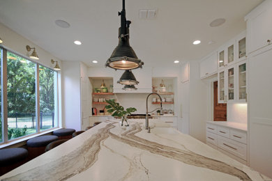 Example of a large transitional concrete floor and gray floor kitchen design in Houston with shaker cabinets, white cabinets, quartz countertops, white backsplash, brick backsplash, paneled appliances, an island and white countertops