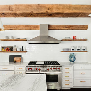 Large farmhouse kitchen photos - Large country kitchen photo in New York with white cabinets, marble countertops, white backsplash, subway tile backsplash, stainless steel appliances and an island