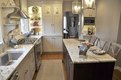 Inspiration for a mid-sized transitional l-shaped medium tone wood floor eat-in kitchen remodel in Other with an undermount sink, shaker cabinets, gray cabinets, granite countertops, white backsplash, subway tile backsplash, stainless steel appliances and an island