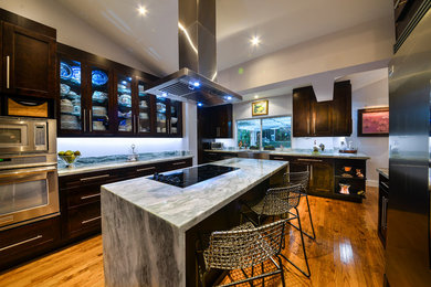 Large contemporary u-shaped kitchen/diner in Miami with shaker cabinets, dark wood cabinets, marble worktops, stainless steel appliances, medium hardwood flooring, an island and a belfast sink.
