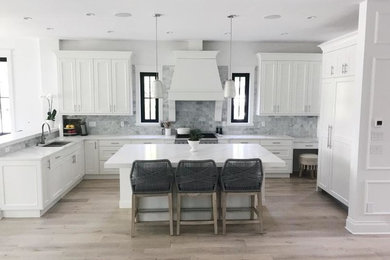 Kitchen - large transitional u-shaped light wood floor and beige floor kitchen idea in Vancouver with an undermount sink, recessed-panel cabinets, white cabinets, quartz countertops, gray backsplash, marble backsplash, paneled appliances, an island and white countertops