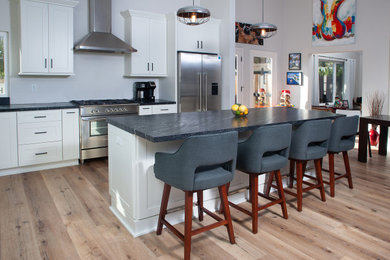 Eat-in kitchen - mid-sized modern l-shaped light wood floor and beige floor eat-in kitchen idea in San Diego with an undermount sink, shaker cabinets, white cabinets, granite countertops, stainless steel appliances, an island and black countertops