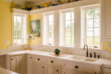 This is an example of a large classic u-shaped kitchen in Portland Maine with a double-bowl sink, beaded cabinets, white cabinets, marble worktops, integrated appliances, dark hardwood flooring and an island.