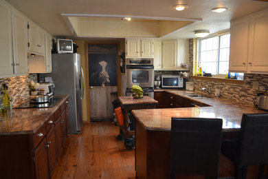 Mid-sized transitional u-shaped medium tone wood floor eat-in kitchen photo in Denver with a double-bowl sink, raised-panel cabinets, dark wood cabinets, granite countertops, multicolored backsplash, glass tile backsplash, stainless steel appliances and an island