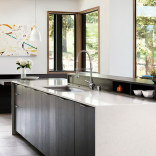 Idée de décoration pour une grand cuisine ouverte minimaliste en L avec un évier encastré, un placard à porte plane, un plan de travail en quartz modifié, un sol en carrelage de porcelaine, un îlot central, des portes de placard blanches, une crédence blanche, une crédence en carreau de céramique et un électroménager encastrable.