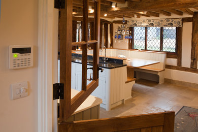 Exempel på ett stort klassiskt kök, med skåp i shakerstil, grå skåp, granitbänkskiva, en köksö, en rustik diskho, svarta vitvaror, klinkergolv i porslin och beiget golv