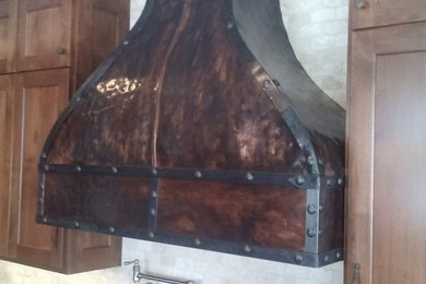 Klassisk inredning av ett stort linjärt kök och matrum, med luckor med infälld panel, skåp i slitet trä, granitbänkskiva, grönt stänkskydd och en köksö
