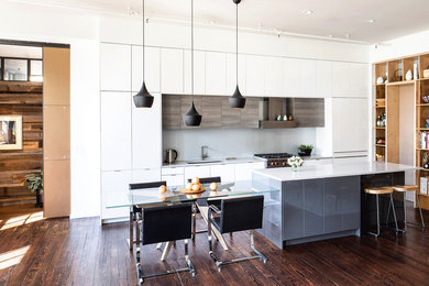 Example of a mid-sized minimalist galley eat-in kitchen design in Philadelphia with an undermount sink, flat-panel cabinets, white cabinets, quartz countertops, gray backsplash, white appliances, an island and white countertops