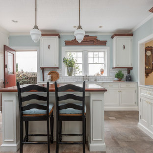 Inspiration for a mid-sized traditional u-shaped separate kitchen in Tampa with an undermount sink, beaded inset cabinets, white cabinets, marble benchtops, white splashback, subway tile splashback, stainless steel appliances, porcelain floors, with island, beige floor, white benchtop and wallpaper.