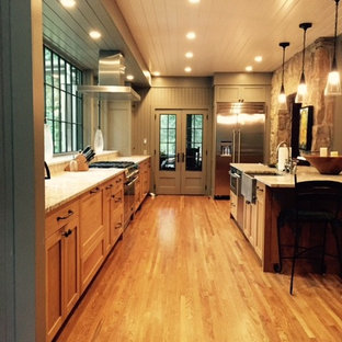 Inspiration for a large country galley open plan kitchen in Other with a farmhouse sink, shaker cabinets, medium wood cabinets, limestone benchtops, stainless steel appliances, medium hardwood floors and with island.
