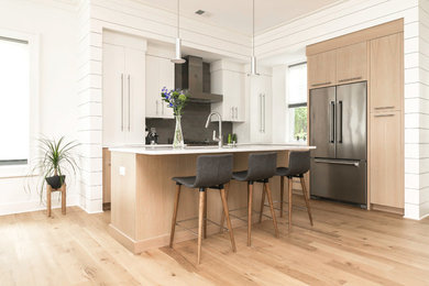 Eat-in kitchen - modern u-shaped light wood floor and brown floor eat-in kitchen idea in Charleston with a drop-in sink, flat-panel cabinets, white cabinets, marble countertops, gray backsplash, subway tile backsplash, stainless steel appliances, an island and white countertops