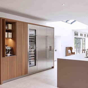 Inspiration pour une grand cuisine américaine parallèle traditionnelle avec un évier 3 bacs, un placard à porte plane, des portes de placard marrons, un plan de travail en surface solide, un sol en carrelage de porcelaine, une péninsule et un plan de travail gris.