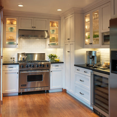 Inspiration for a timeless u-shaped enclosed kitchen remodel in San Francisco with subway tile backsplash, stainless steel appliances, white cabinets, white backsplash and recessed-panel cabinets