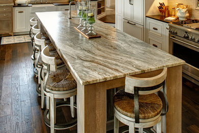 Huge transitional l-shaped dark wood floor open concept kitchen photo in Other with a farmhouse sink, beaded inset cabinets, white cabinets, granite countertops, beige backsplash, mirror backsplash, stainless steel appliances, an island and multicolored countertops