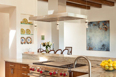 Inredning av ett modernt stort kök, med en dubbel diskho, släta luckor, skåp i ljust trä, marmorbänkskiva, rostfria vitvaror, klinkergolv i porslin och en köksö