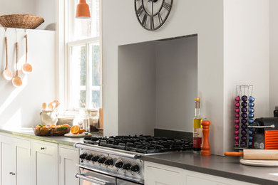 Foto di una cucina country con ante con riquadro incassato, ante bianche, elettrodomestici in acciaio inossidabile e pavimento grigio