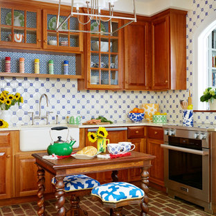 Design ideas for a country u-shaped separate kitchen in DC Metro with a farmhouse sink, medium wood cabinets, blue splashback, ceramic splashback, stainless steel appliances, brick floors, with island, raised-panel cabinets and brown floor.